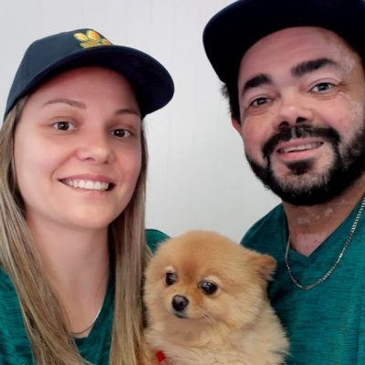 	Dog Play Centre Perth owners smiling with a fluffy Pomeranian dog